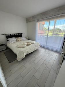 um quarto com uma cama e uma grande janela em Saint Cyprien Golf View 2 bedrooms Apartment , 900 m from the beach em Saint-Cyprien
