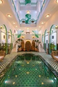 a pool in the lobby of a hotel with green tiles at Pisces Hotel Hue in Hue