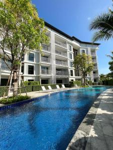 una piscina frente a un edificio en Comfy 2-King Bed Condo - 3 Min to Rawai Beach at The Titile V Condo's en Phuket