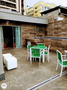 un patio con mesa y sillas en la azotea en Cobertura Premium Botafogo, en Río de Janeiro