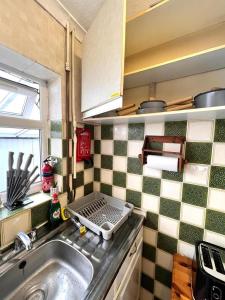 a kitchen with a sink and a counter top at Stonehouse Cottage Near QE & UOB in Birmingham