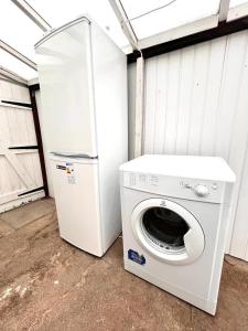 a washing machine and a refrigerator in a garage at Stonehouse Cottage Near QE & UOB in Birmingham