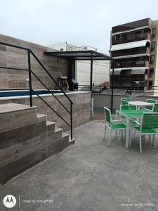 un patio con una mesa y sillas verdes y una escalera en Cobertura Premium Botafogo, en Río de Janeiro