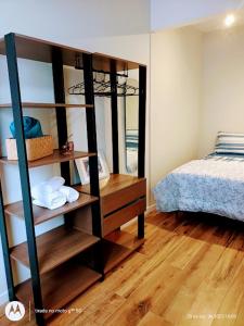 1 dormitorio con 1 cama y estante de libros con toallas en Cobertura Premium Botafogo, en Río de Janeiro