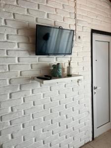 a tv mounted on a brick wall with a shelf at Casa MAR in Playa Unión