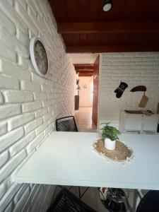 a white brick wall with a table and a clock at Casa MAR in Playa Unión