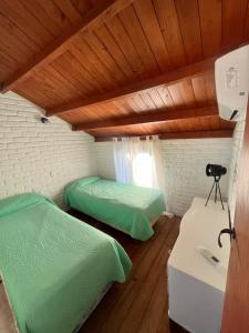 two beds in a room with wooden ceilings at Casa MAR in Playa Unión