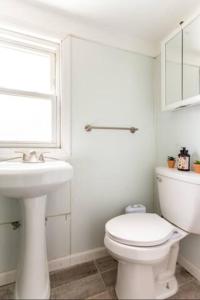 La salle de bains blanche est pourvue de toilettes et d'un lavabo. dans l'établissement cozzy room with private entrance and drive way, à Arlington
