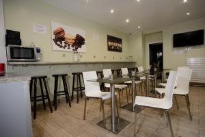 bar z białymi krzesłami i stołami w restauracji w obiekcie Enjoy Hostel w Paryżu