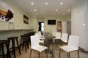un restaurante con mesas y sillas blancas y un bar en Enjoy Hostel en París