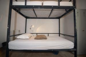 a bedroom with a bunk bed with white sheets at Enjoy Hostel in Paris