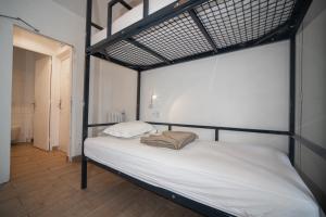 a bedroom with a bunk bed with white sheets at Enjoy Hostel in Paris