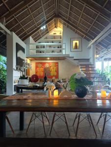 a dining room with a wooden table with candles on it at The Living Room Siargao in General Luna