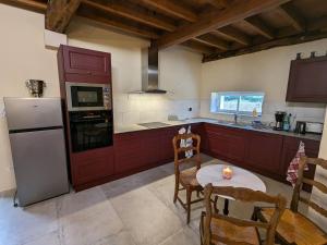 a kitchen with a refrigerator and a table with chairs at Gîte chaleureux avec jardin, accueil chevaux, proche Loire à Vélo et sites historiques - FR-1-590-415 in Sigloy +25 photos