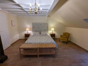 a bedroom with a bed and a chandelier at Gîte chaleureux avec jardin, accueil chevaux, proche Loire à Vélo et sites historiques - FR-1-590-415 in Sigloy
