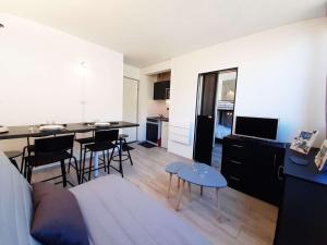 ein Wohnzimmer mit einem Sofa und eine Küche mit einem Tisch in der Unterkunft Studio confort 4 pers avec casier à ski et équipements complets à Piau Engaly - FR-1-457-328 in Aragnouet + 1 Foto