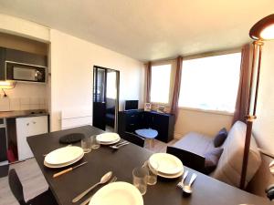 een keuken en een woonkamer met een tafel en een bank bij Studio Piau-Engaly, 1 pièce, 4 personnes - FR-1-457-328 in Aragnouet