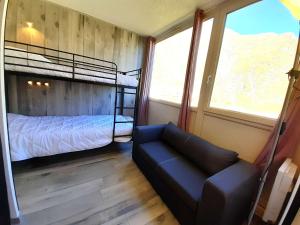 - une chambre avec des lits superposés et un canapé dans l'établissement Studio confort 4 pers avec casier à ski et équipements complets à Piau Engaly - FR-1-457-328, à Aragnouet