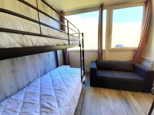 ein Schlafzimmer mit einem Etagenbett und einem Stuhl in der Unterkunft Studio confort 4 pers avec casier à ski et équipements complets à Piau Engaly - FR-1-457-328 in Aragnouet