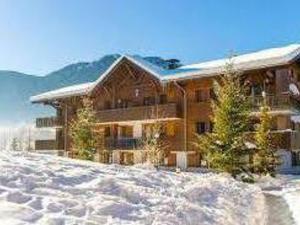 una gran casa de madera en la nieve con montañas en Appartement Samoëns, 2 pièces, 4 personnes - FR-1-624-144, en Samoëns