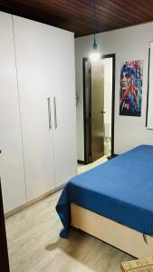 1 dormitorio con 1 cama azul y armarios blancos en Casa na Praia Brava SC, en Balneário Camboriú