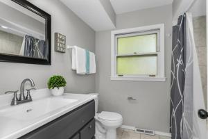 ein Badezimmer mit Waschbecken und Toilette und einem Fenster in der Unterkunft Prime Location, Cozy & Spacious home in Schaumburg in Schaumburg + 13 Fotos