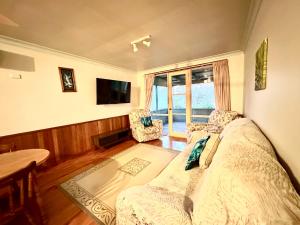 a bedroom with a bed and a table and a window at Carriageway Retreat - Unique Red Rattler Carriages and Units in Brookfield