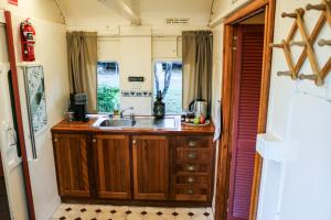 a kitchen with a sink in a train at Carriageway Retreat - Unique Red Rattler Carriages and Units in Brookfield