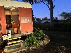 una pequeña casa con la puerta abierta en un patio en Carriageway Retreat - Unique Red Rattler Carriages and Units, en Brookfield