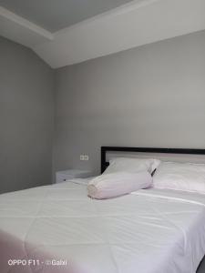 a white bed with white sheets and pillows at Mount Rinjani Guest House in Sajang