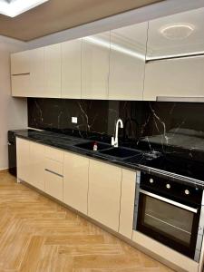 eine Küche mit weißen Schränken und einer schwarzen Arbeitsplatte in der Unterkunft FaFa Deluxe apartments in Golem