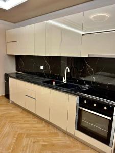 a kitchen with white cabinets and a black counter top at FaFa Deluxe apartments in Golem