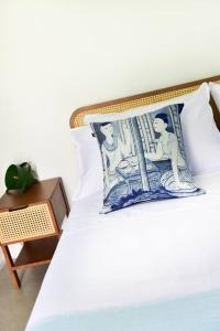 a bed with a pillow on it with a side table at Bungalow Khao Lak in Khao Lak