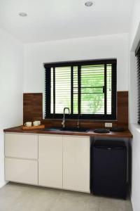 a kitchen with a sink and a window at Bungalow Khao Lak in Khao Lak