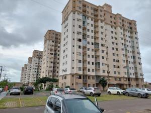 a large building with cars parked in a parking lot at A FELICIDADE MORA AQUI in São Luís