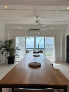 a large wooden table in a living room with the ocean at Beachfront Reunions @ Canyon Cove in Nasugbu +43 photos