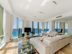 a living room with a white couch and a television at Style and Amazing Views-Sub Penthouse in Gold Coast