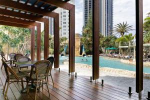 a patio with a table and chairs and a pool at Style and Amazing Views-Sub Penthouse in Gold Coast