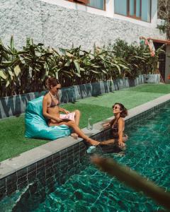 un hombre y una mujer sentados junto a una piscina en SEA HILLS Kuta Lombok, en Kuta Lombok