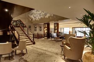a lobby with a staircase and chairs and a table at Glasgow Grosvenor Hotel in Glasgow