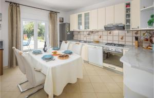 cocina con mesa y mantel blanco en Awesome Home In Visnjan With Kitchen, en Višnjan