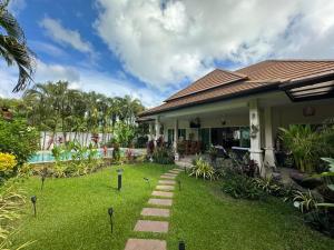 a house with a garden in front of it at Pacotte Villa by G Estate in Rawai Beach