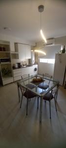 una cucina con tavolo in vetro e 2 sedie di Confortable y Amplio loft a Mendoza