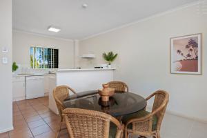a kitchen and dining room with a glass table and chairs at Cairns City Family Apartment - Wifi -Netflix - Pool in Cairns North +6 photos