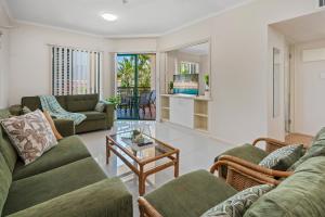 a living room with two couches and a table at Cairns City Family Apartment - Wifi -Netflix - Pool in Cairns North
