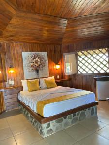 sypialnia z dużym łóżkiem i drewnianymi ścianami w obiekcie Bungalows Malú w mieście Cahuita