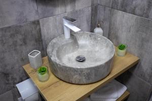 uma casa de banho com um lavatório de betão com um lavatório em Alpasio Rentals 2 em Galaţi