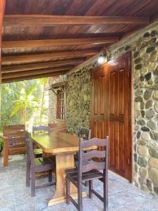 una mesa de madera y sillas en un patio en Bungalows Malú, en Cahuita