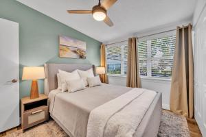 a bedroom with a bed with a ceiling fan and a window at Best of Both Worlds Lakehouse in Orlando