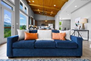 un sofá azul con almohadas naranjas en la sala de estar. en Modern Cabin near Smoky Mountain National Park en Gatlinburg